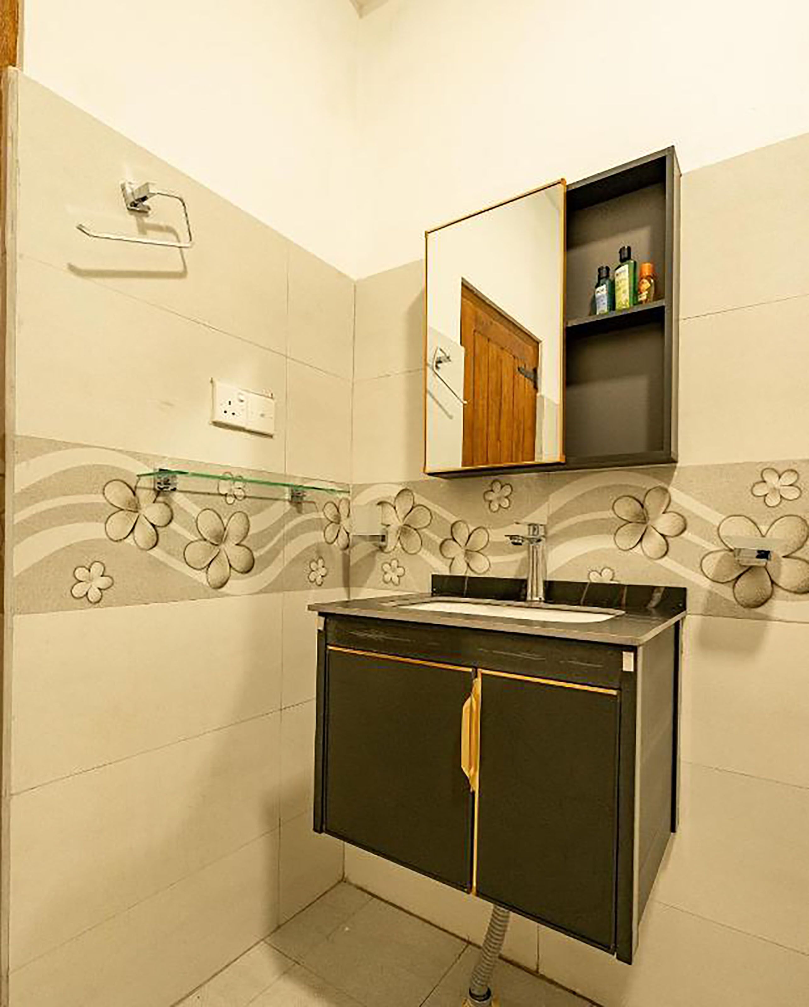 A bathroom with a sink, mirror, and toiletries shelf.