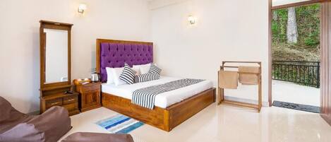Un dormitorio con una cama grande, una mesita de noche de madera, un aparador, un espejo, un banco y vistas al exterior.
