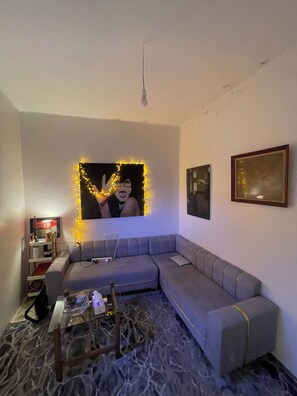 A living room with a grey sofa, a coffee table, a TV, and a framed picture on the wall.
