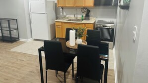 A compact kitchen with wooden cabinets, a built-in oven, and a microwave. - Exquisite private 1-bedroom apartment in delightful Newark with modern amenities (Newark)