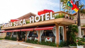 Hotel 'Cabana Suica' met een opvallend bord, een terras en vlaggen.
