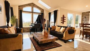 A spacious living room with a grand piano, a coffee table, and a sofa.