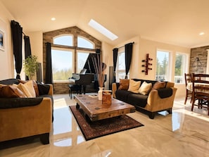 A spacious living room with a grand piano, a coffee table, and a sofa.