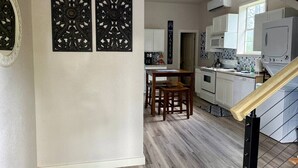 A kitchen with white cabinets, a wooden dining table, and two chairs. - DFW Hideaway located right off I-35W and near so many area attractions! (Argyle)