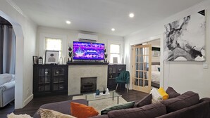 Ein Wohnzimmer mit Kamin, Fernseher und einer Couch.