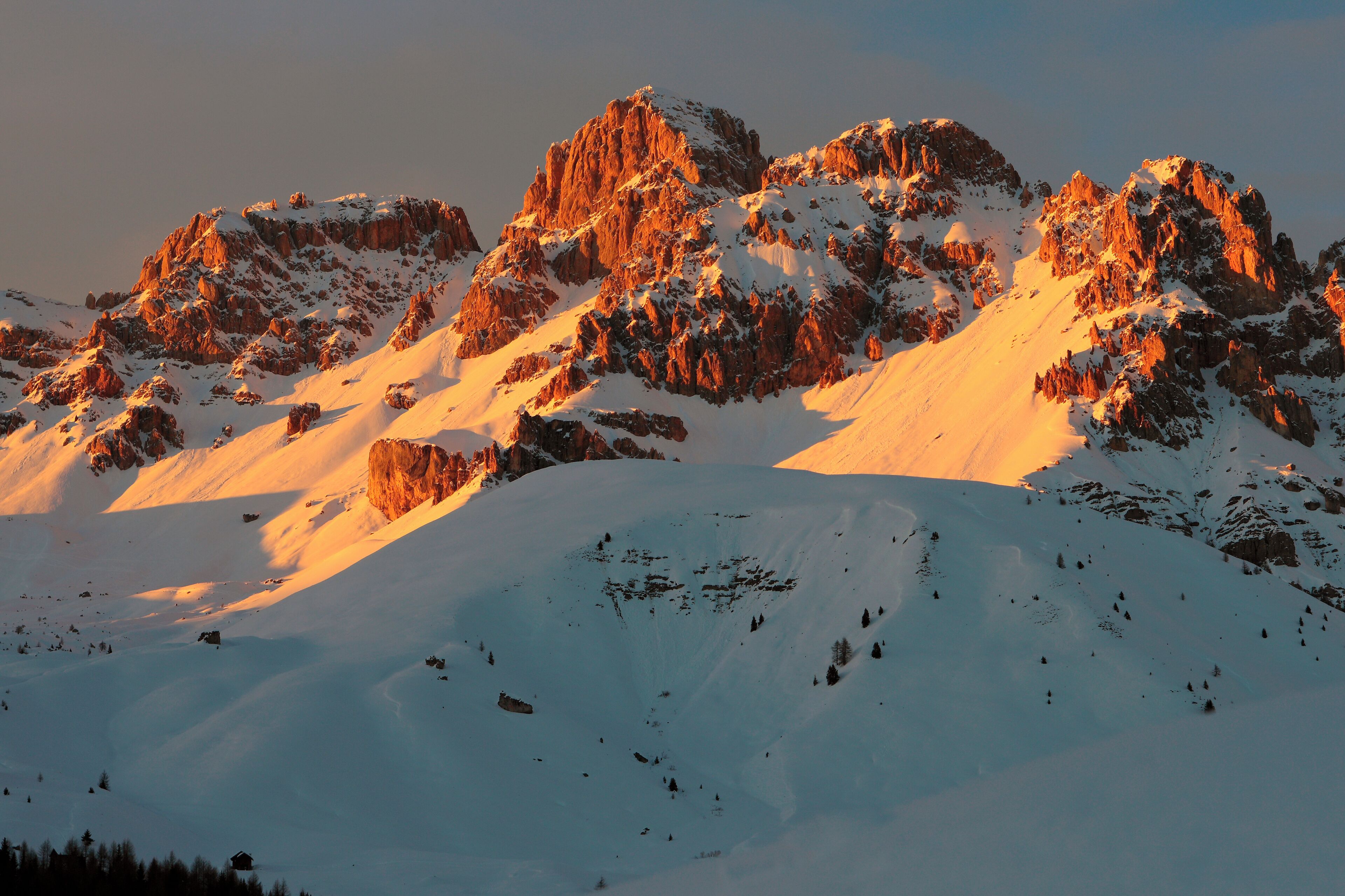 A mountainous landscape with snow-covered peaks and rocky outcrops.
