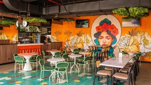 A restaurant interior with a mural, green chairs, and a bar area. - Luxury Stay in Nucleo Sabana, AC, WIFI, Pools, Parking and 30 more amenities (San José)