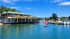 A waterfront restaurant with outdoor seating and a view of the marina.