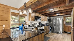 A modern kitchen with wooden cabinets, stainless steel appliances, and a large island.