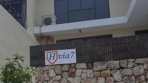 A modern building with a stone wall and a sign reading "H via 7". - 4 Stunning Cool Studio in tourist area (Ciudad de Guatemala)