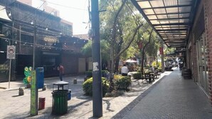 A pedestrian street with outdoor seating, a covered area, and a building with a sign. - 4 Stunning Cool Studio in tourist area (Ciudad de Guatemala)