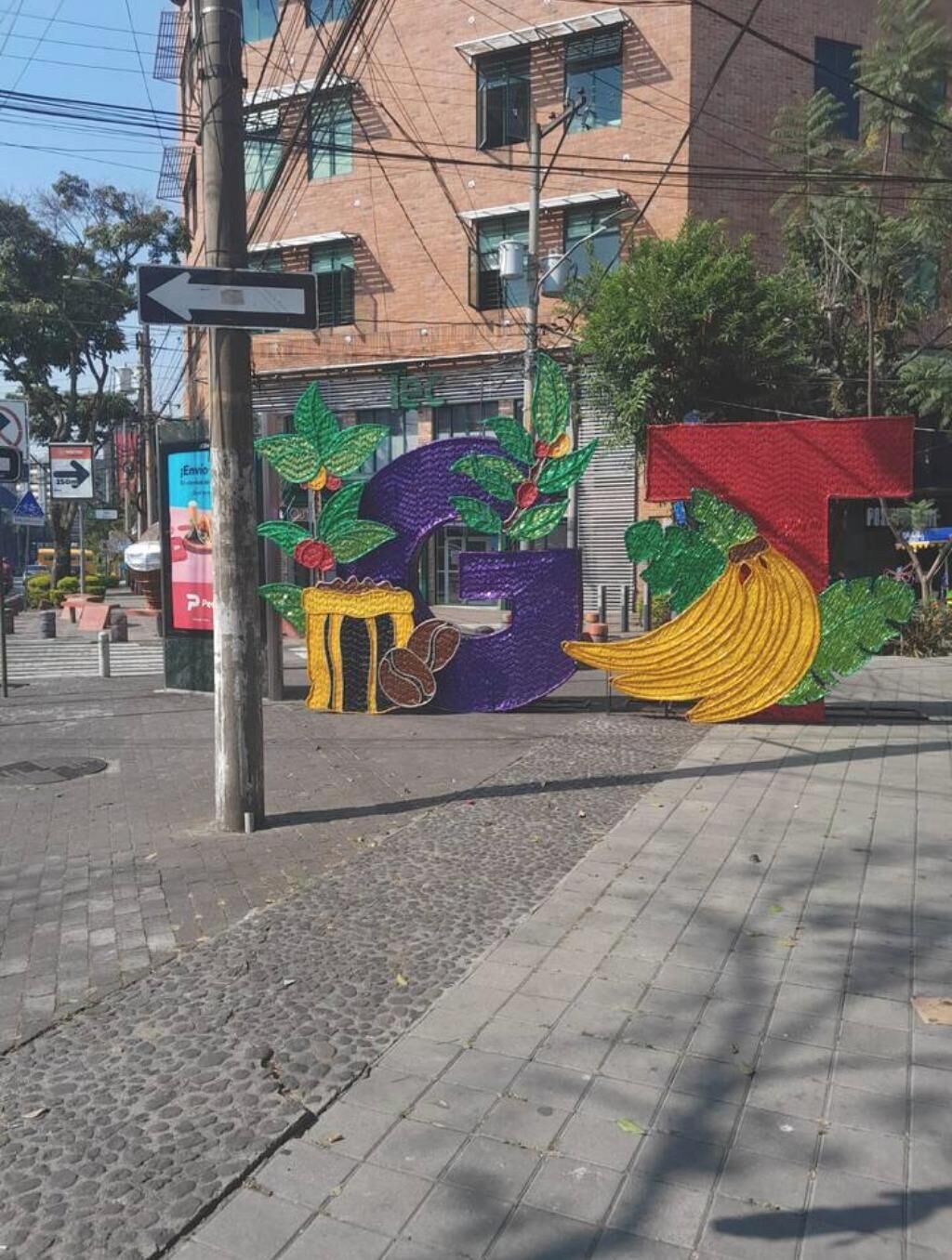 A street scene with a colorful mural of bananas and a table.