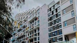 A multi-story residential building with balconies, a glass facade, and a pedestrian area with seating and a mural. - 7 Cool studio at the best zone (Ciudad de Guatemala)