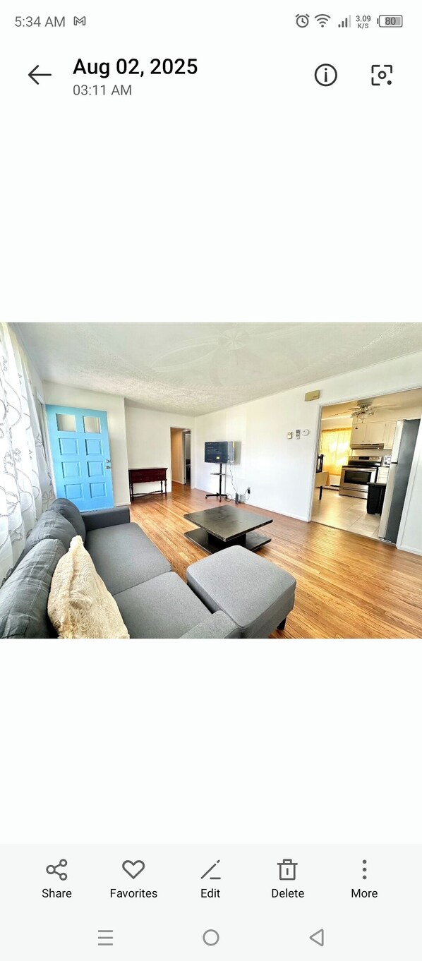 A modern living room with a sofa, coffee table, and a TV.