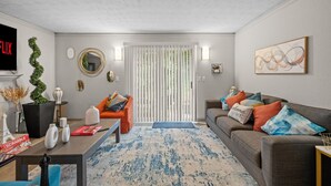 A living room with a fireplace, two sofas, a coffee table, and a TV. - 2 Lux King Beds - Short Walk to Truist Park (Smyrna)