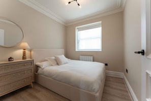 A bedroom with a bed, a dresser, a mirror, and a window. - Host Stay Albion Place (Ramsgate)