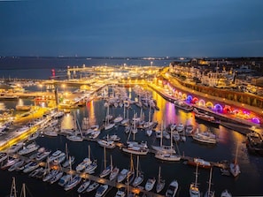 A marina with numerous boats docked, connected by piers and illuminated by street lights. - Host Stay Albion Place (Ramsgate)