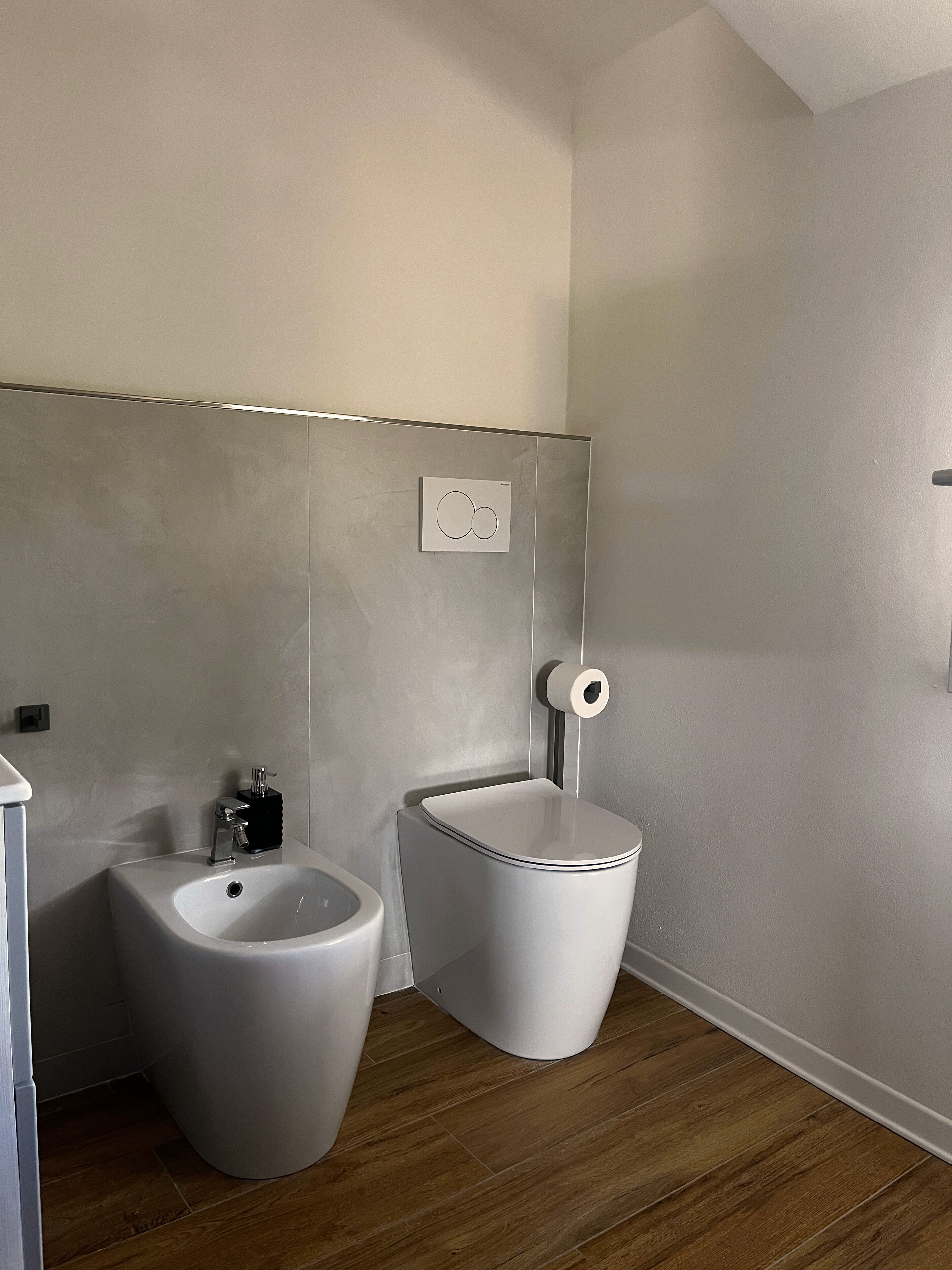 Ein modernes Badezimmer mit einer Bidet-Funktion, Toilette und Waschbecken.