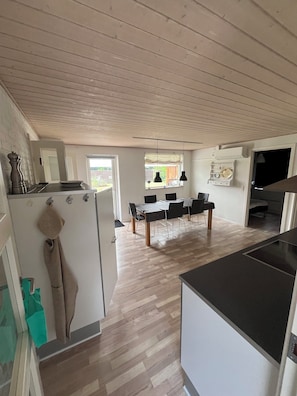 Eine moderne Küche mit Essbereich, Holzboden und Blick ins Freie.