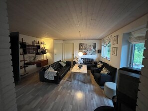 Una sala de estar con un sofá, una mesa de centro y estantes con objetos decorativos.