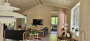 Un intérieur en bois comprenant un téléviseur, un coin repas et une petite cuisine.