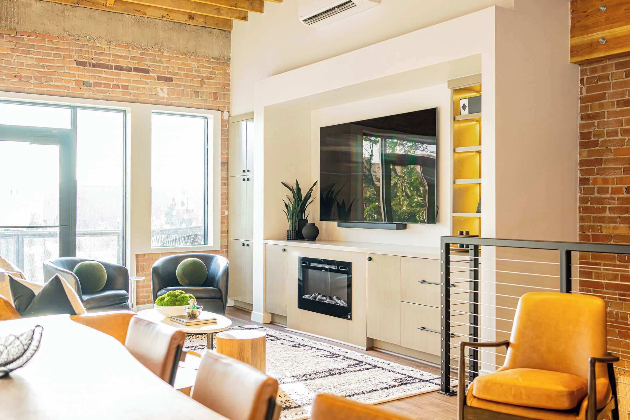 Una sala de estar moderna con chimenea, una televisión de pantalla plana y un comedor con mesa y sillas.
