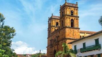 A historic building with a bell tower, steps leading up to it, and a clear sky.