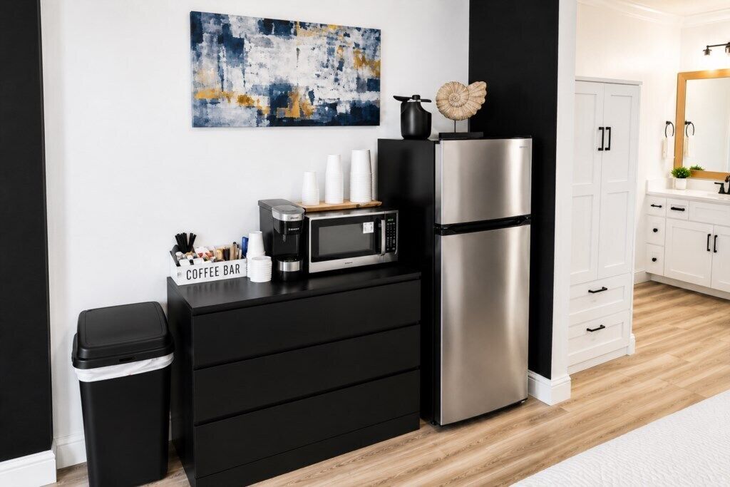 A modern kitchen with a coffee bar, microwave, and stainless steel refrigerator.