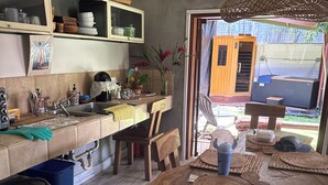 A kitchen with wooden cabinets, a sink, and a dining area with a large wooden table.