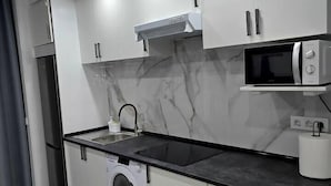 A modern kitchen with a washing machine, a microwave, and a sink. - Apartment in Southern Madrid for Groups/Families (Leganes)