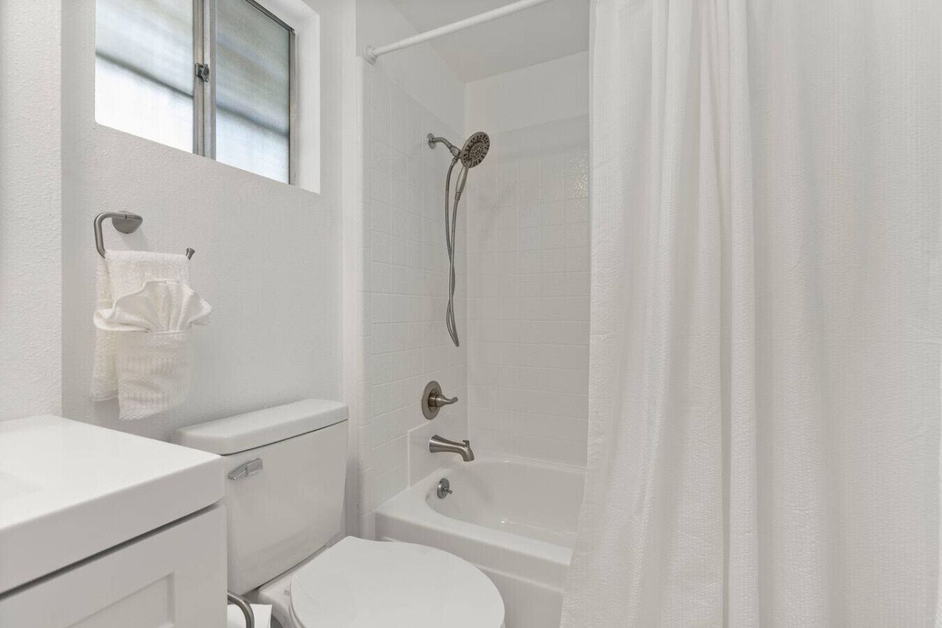 Un baño moderno con inodoro, lavamanos y ducha.