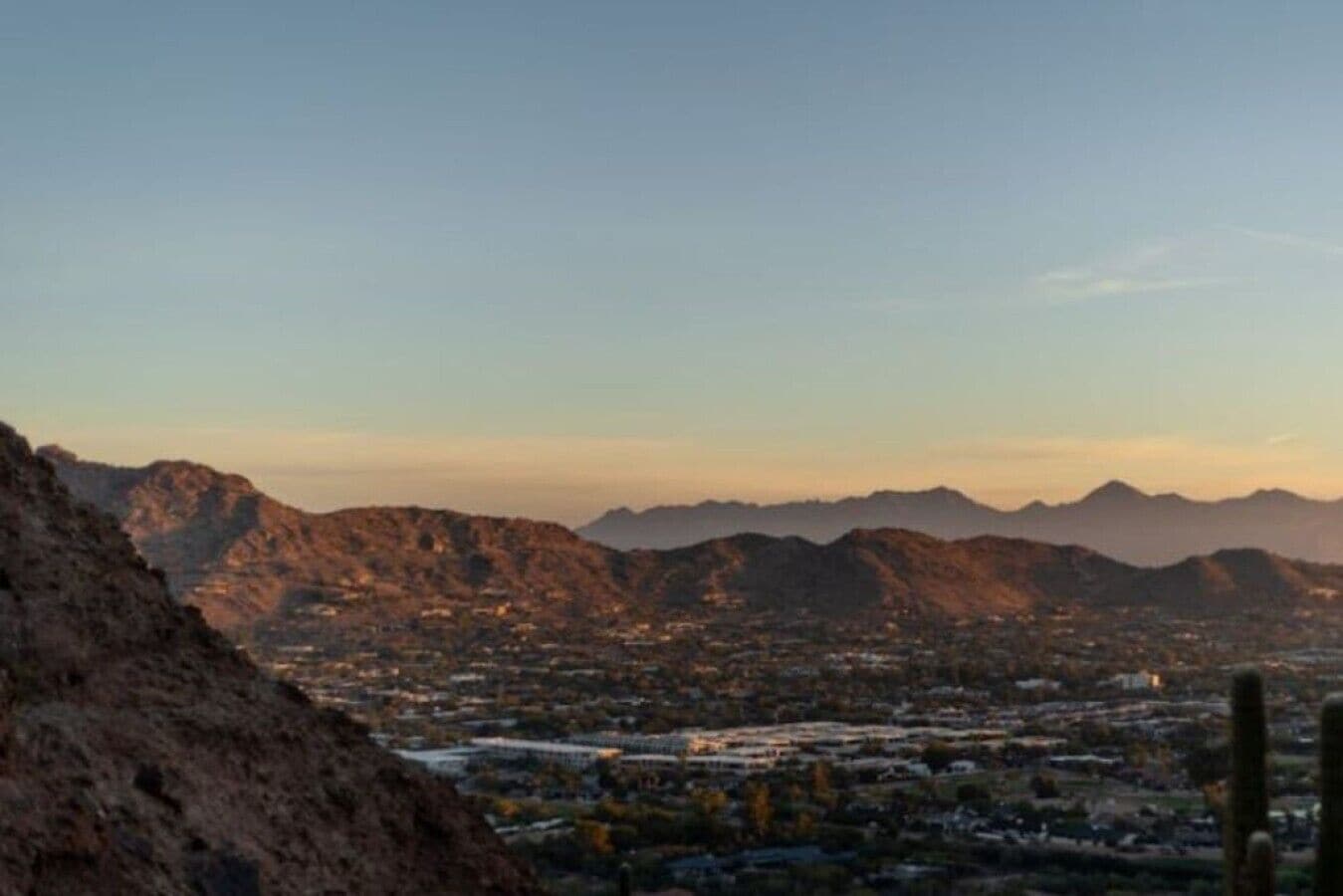 Un paysage montagneux avec une ville située dans une vallée au premier plan.