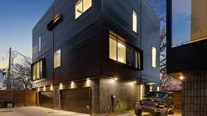 A modern two-story building with large windows and a garage.