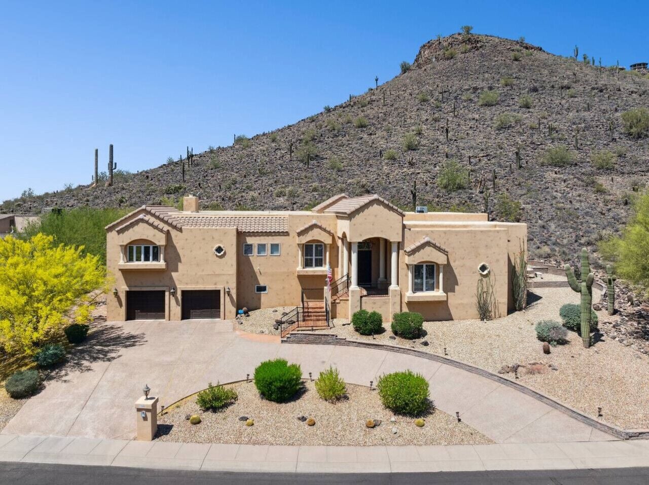 A two-story house with a front entrance, garage, and a driveway leading to the front door.
