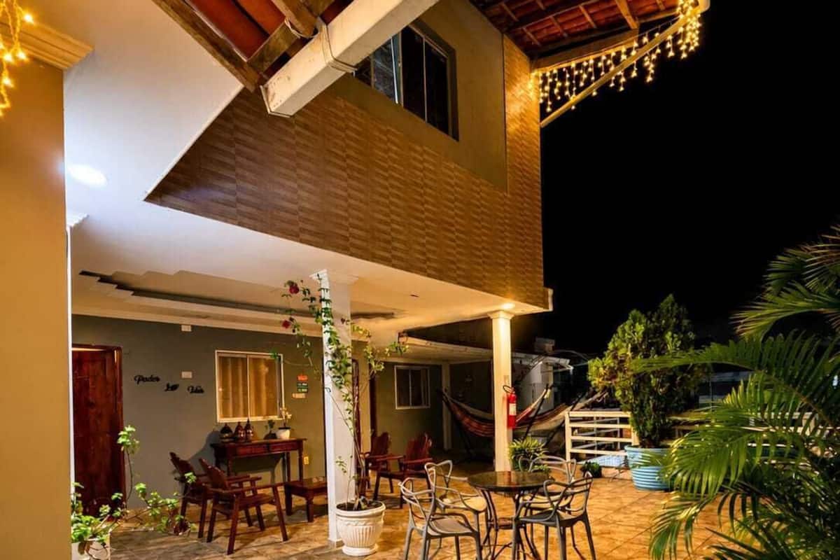 An outdoor patio area with tiled flooring, wooden furniture, and potted plants.