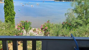 A coastal view with boats on the water, greenery, and a clear sky.