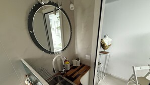 A modern bathroom with a wooden vanity, a large mirror, and a white sink.