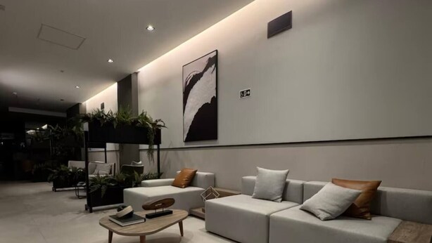 Una sala de estar moderna con un conjunto de sofá, una mesa de centro y un televisor montado en la pared.