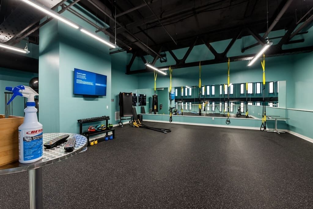 Un gimnasio con equipo de ejercicio, un espejo y una pared azul.