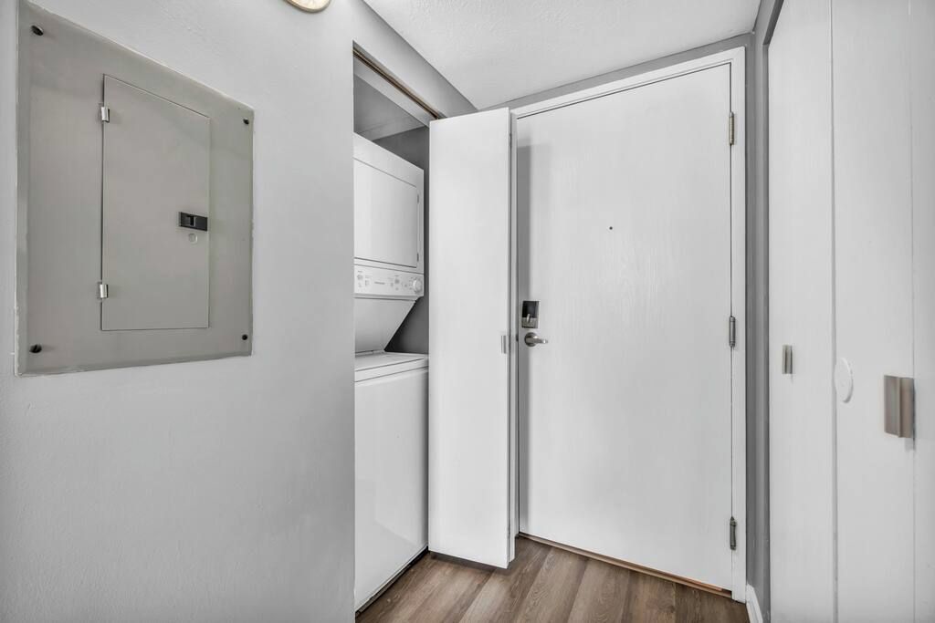 A hallway with a white door, a white wardrobe, and a built-in washing machine.