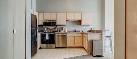 Una cocina moderna con armarios de madera, electrodomésticos de acero inoxidable y un diseño funcional.