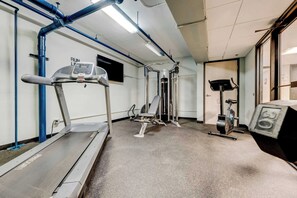 A fitness center with a treadmill, weight machines, and a stationary bike. - HUGE Loft in Heart of Downtown • Pool/Sauna • Gym (Cleveland)