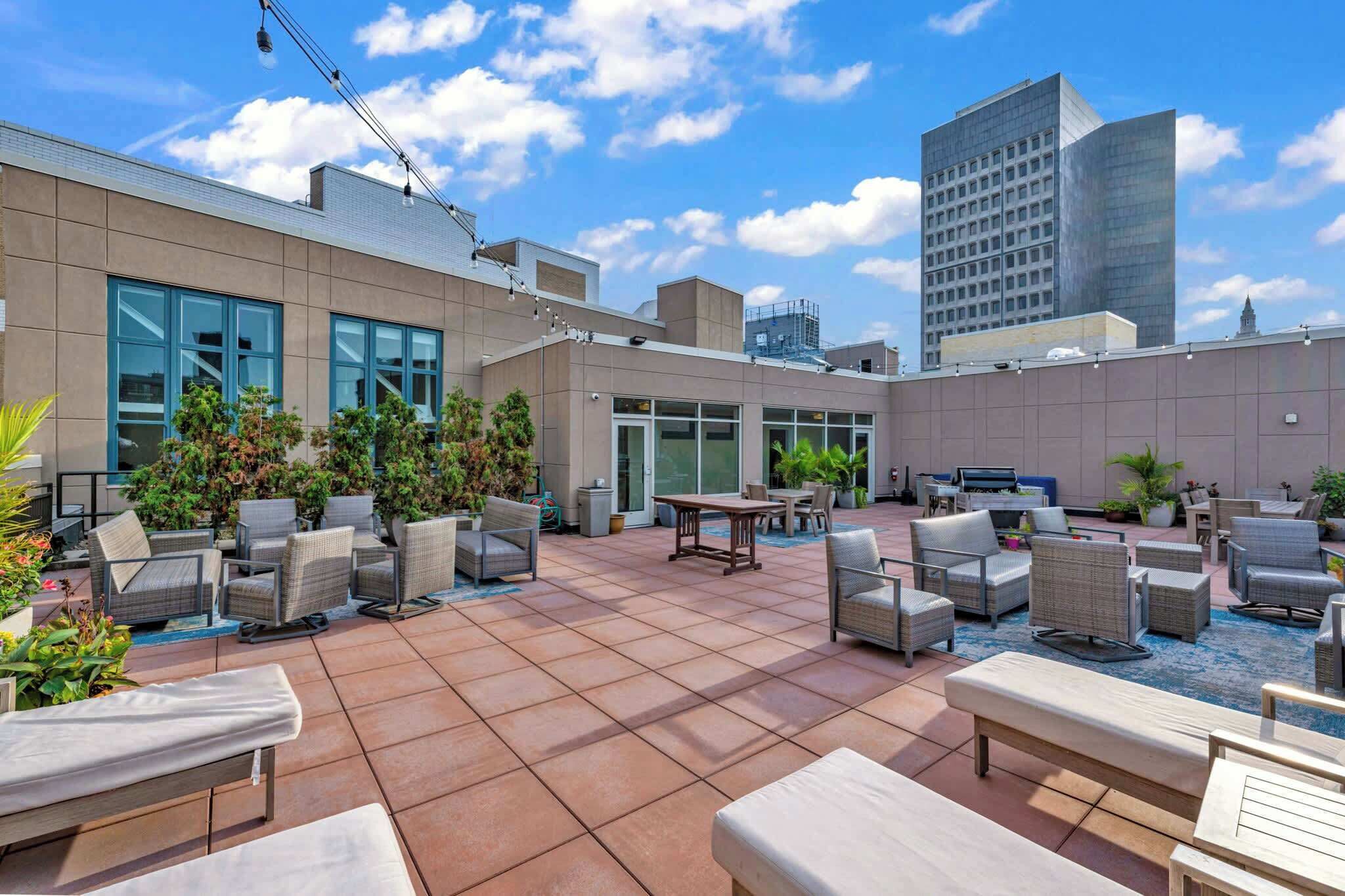 A rooftop patio with outdoor seating and potted plants.