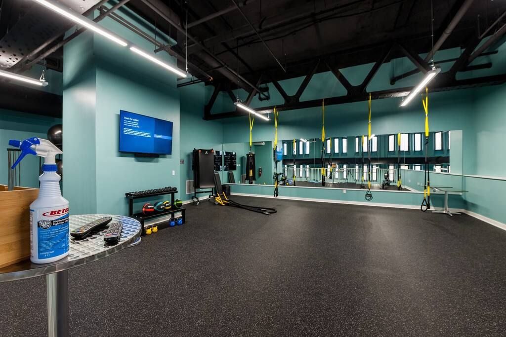 A gym with exercise equipment, a mirror, and a blue wall with a sign.