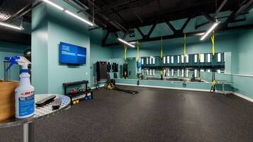 A gym with exercise equipment, a mirror, and a blue wall with a sign.