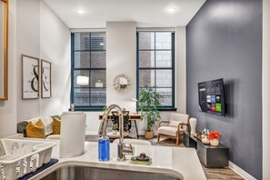 A modern kitchen with a stainless steel sink, a built-in oven, and a large window. - Central 1B in Heart of Downtown • Pool & Spa • Gym (Cleveland)