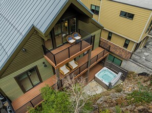 Ein mehrstöckiges Haus mit Balkon, Whirlpool und einer Steinterrasse.