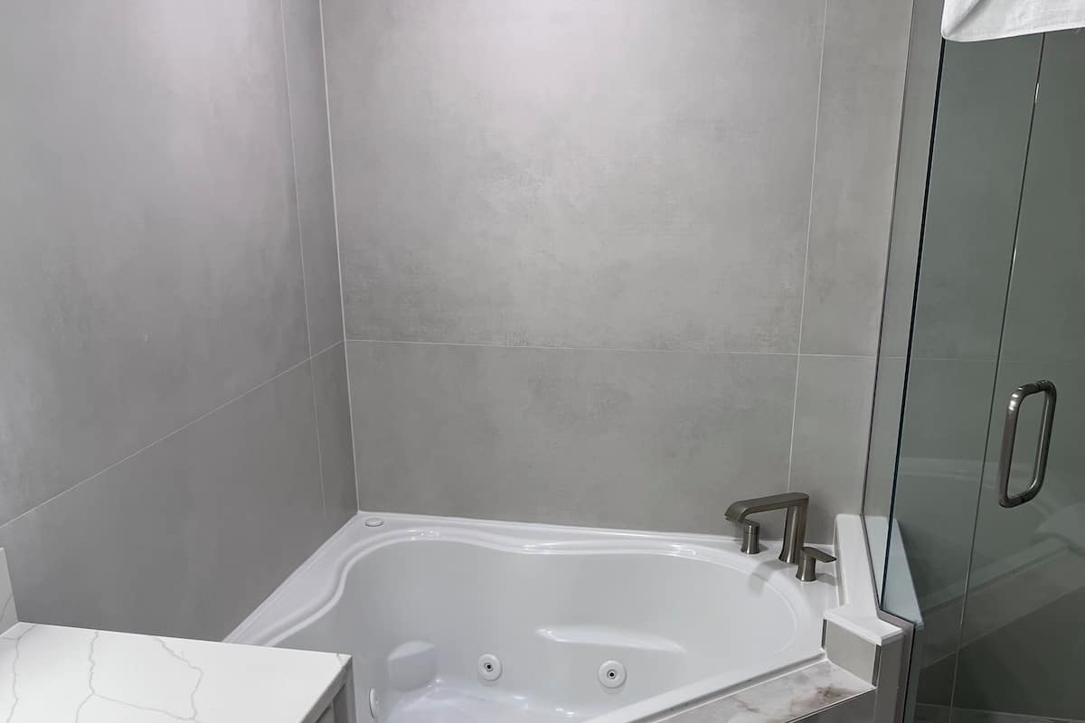 Um banheiro moderno com uma banheira independente, box de vidro e toucador de mármore.