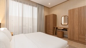 Une chambre à coucher avec un grand lit, un bureau et des armoires.
