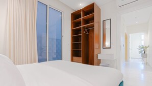 A bedroom with a large bed, a walk-in closet, and a view of the outside. - Two Bedroom Colorful & Exotic Flat in Alrabie (Riyadh)